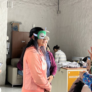 Foto docente con mascara de una activdad.